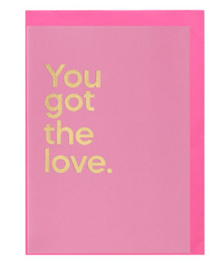 A pink greeting card that reads 'You got the love' in gold text